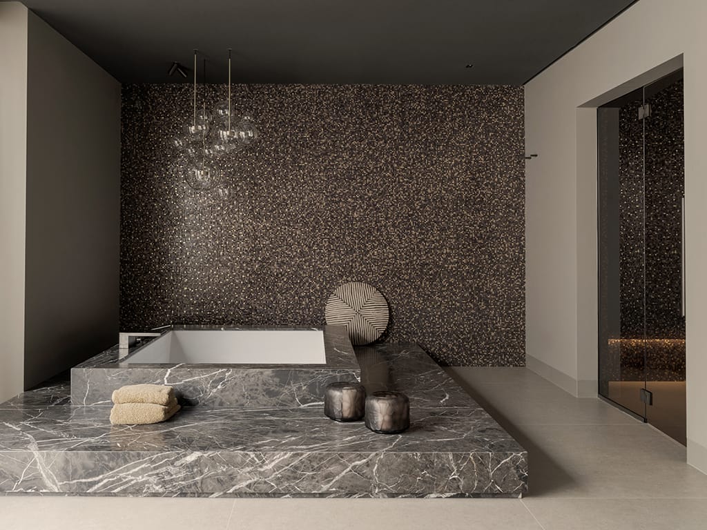 Bad ingebouwd in marmer Havana Brown voor een wand van Bisazza-mozaïek met 24-karaats goud, naast de stoomdouche.