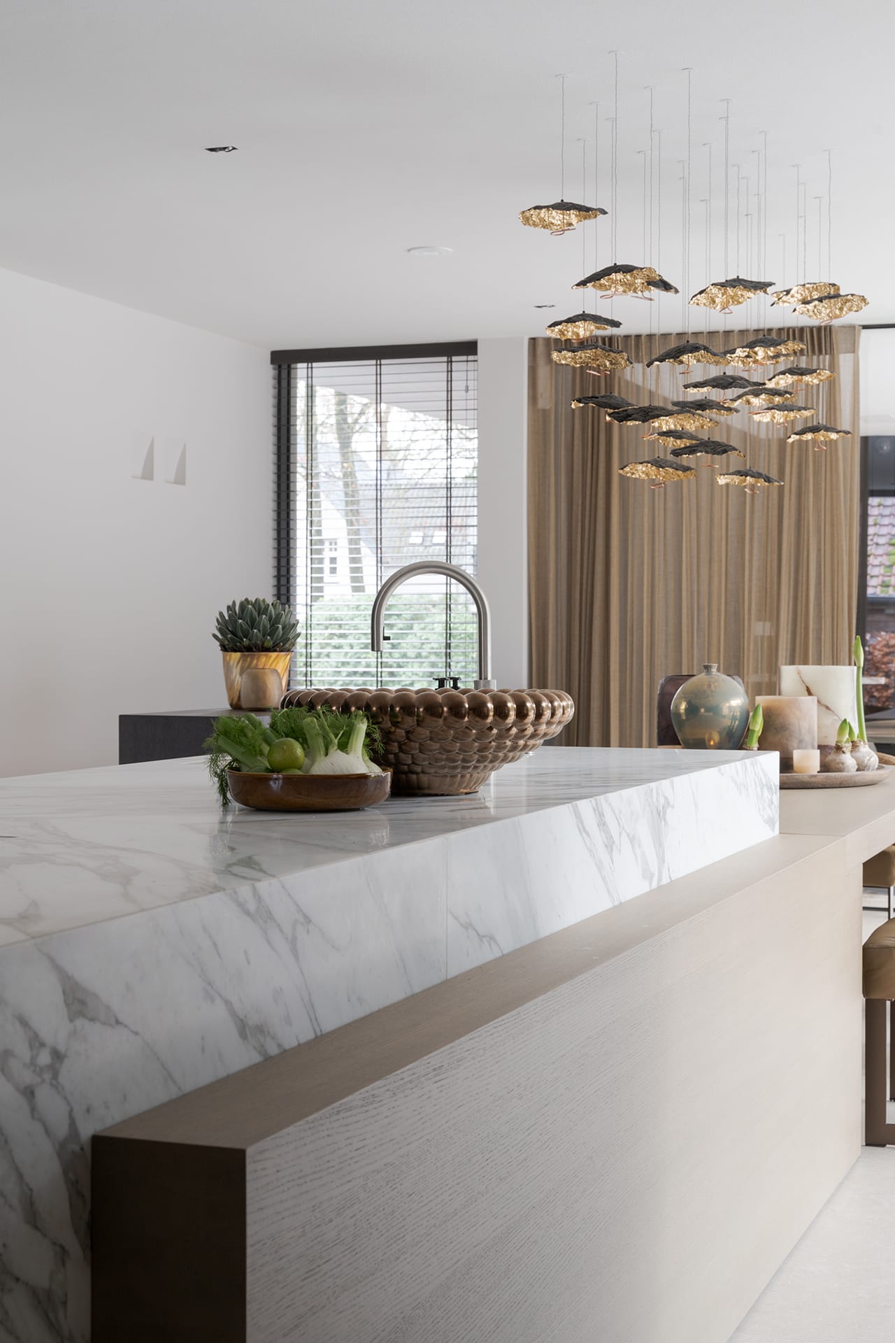 Quooker Flex in RVS op het keukeneiland van marmer Calacatta Vagli, met daarachter de Gold Moon van Catellani & Smith.