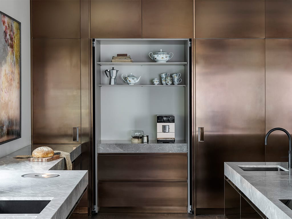 Arclinea Convivium kastenwand in PVD brons met New Pocket System: de deuren schuiven weg voor een koffienis.