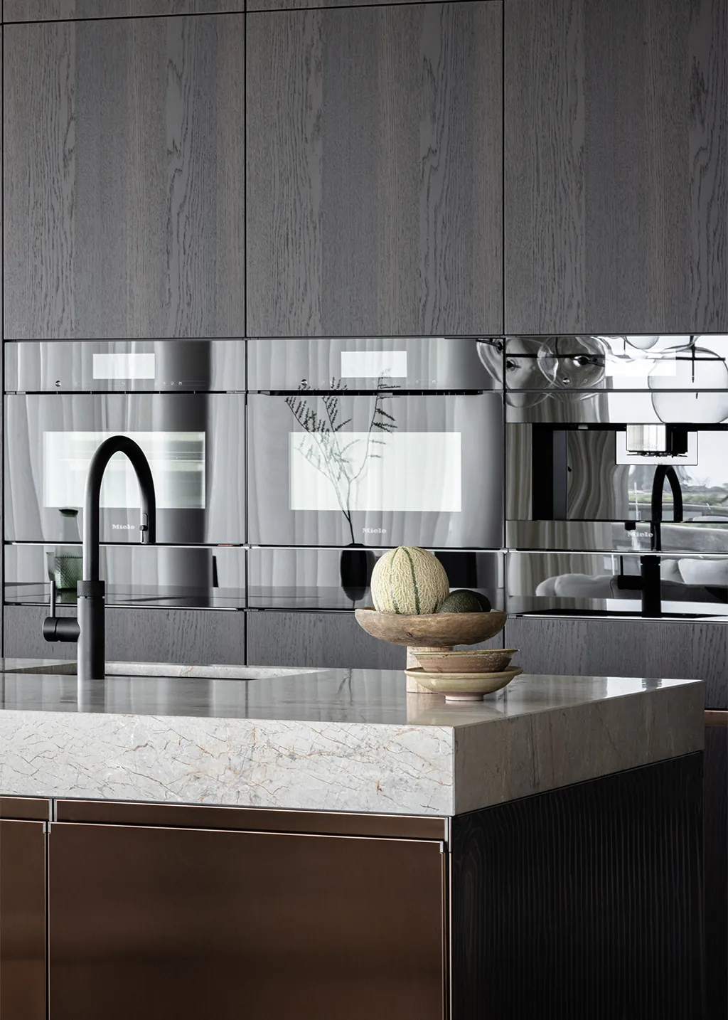 Arclinea Convivium keuken in PVD Bronze met Bianco Carrara marmeren werkblad en wandkasten in Black Ash houtfineer