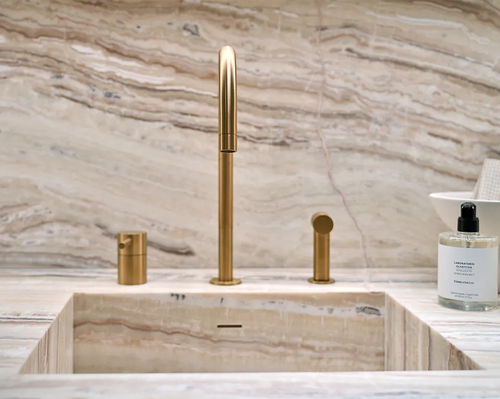 Keuken met Traveronyx beige marmer wastafel en gouden kraan natuursteen met doorschijnende onyx structuur