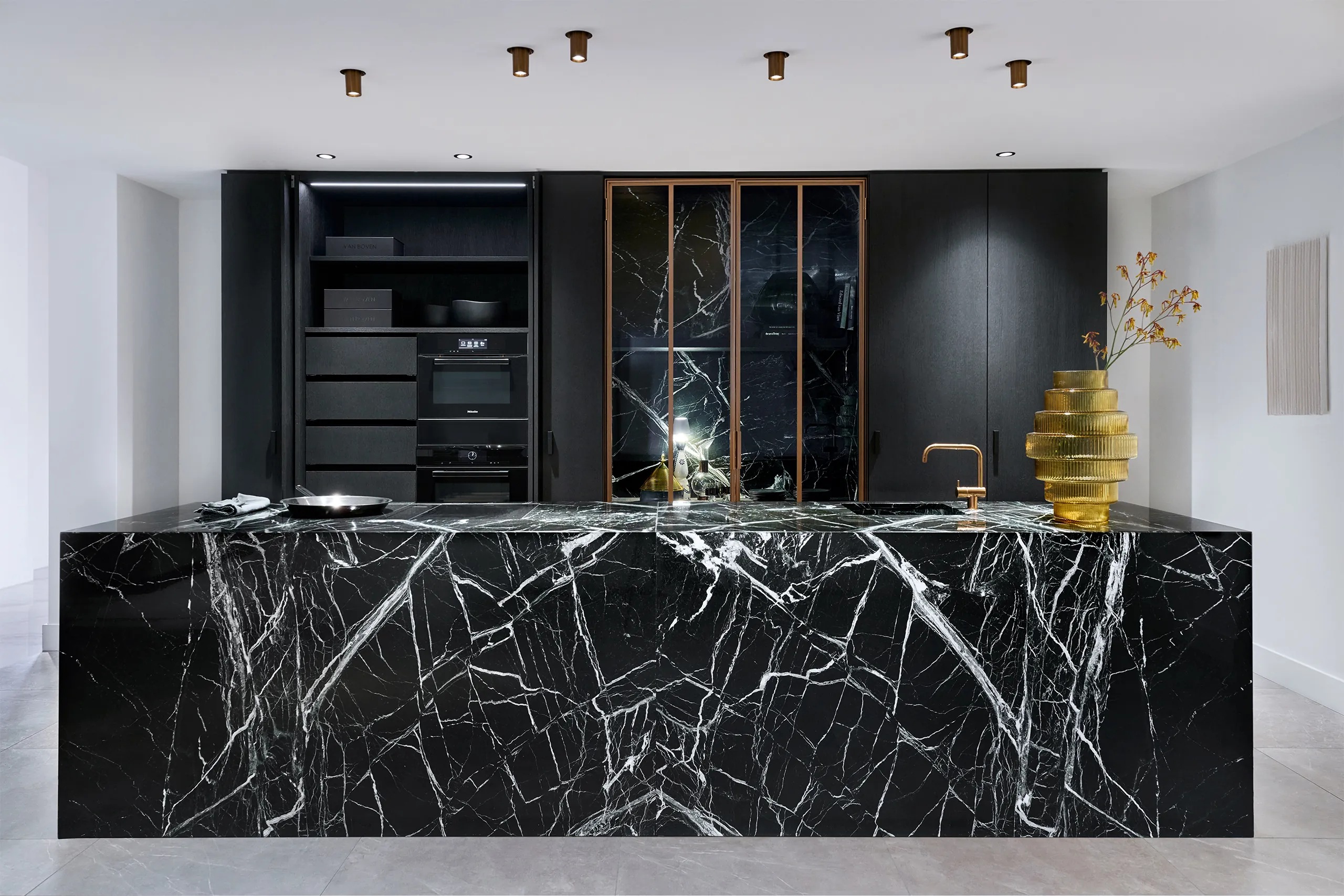 Eggersmann Vancouver keuken met groen marmeren eiland zwarte kastenwand stalen deuren en Miele apparatuur greeploos design