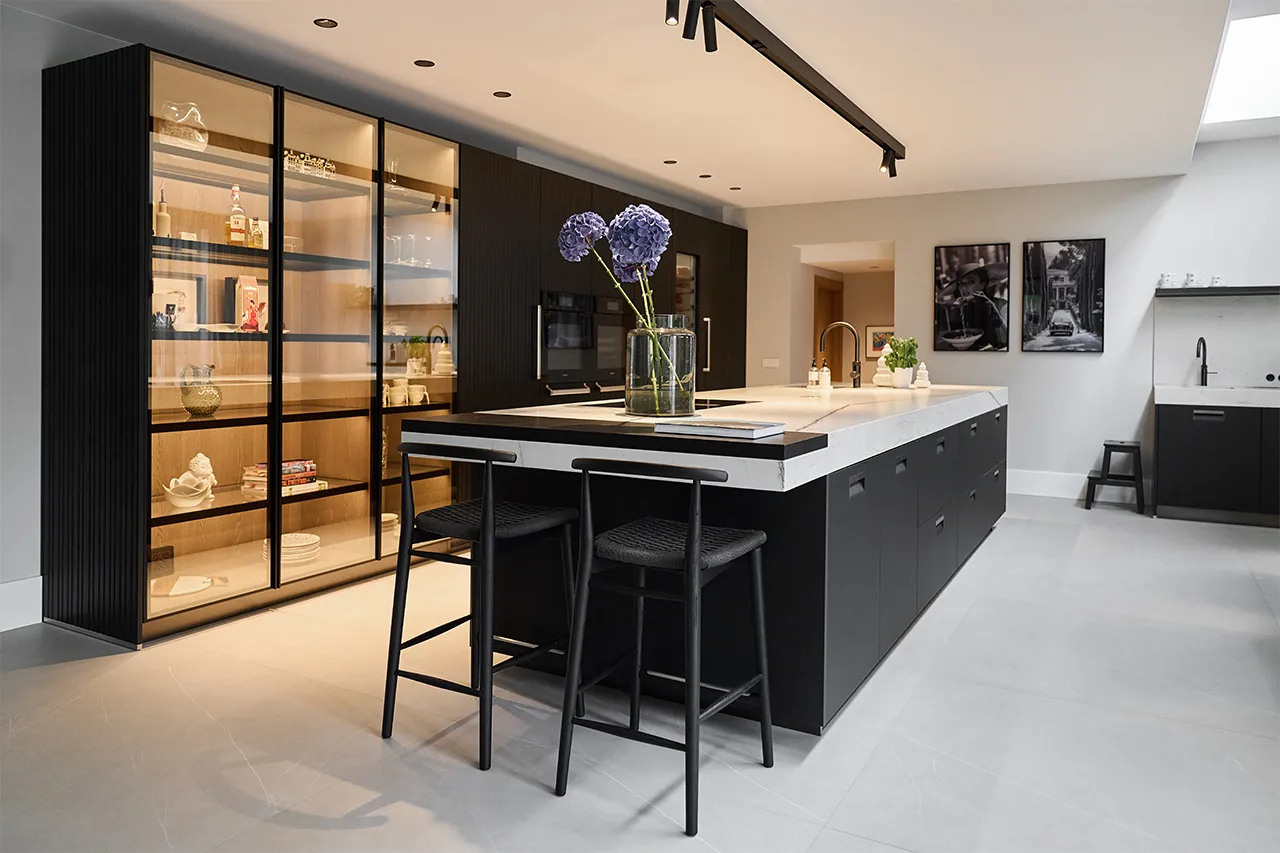 Arclinea Italia keukeneiland in zwart met wit kwartsiet werkblad en B&B Italia Jens Low barkrukken Italiaans designkeuken