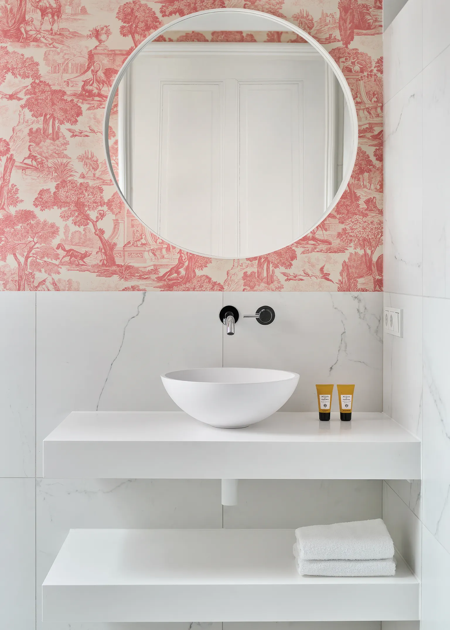 Badkamer met Fantini witte keramische opzetkom keramische tegels in marmerlook en roze behang Italiaans kranendesign klassieke elegantie
