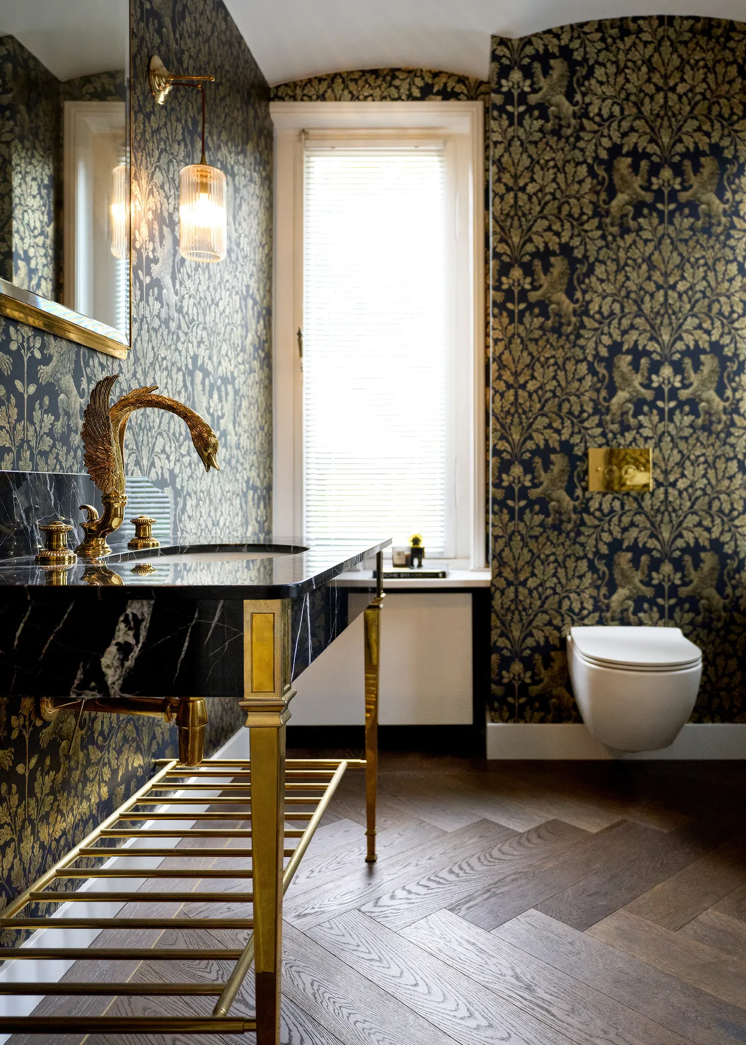 Badkamer met THG Paris Cygne zwanenkraan in 24kt goud marmeren wastafel klassiek behang en visgraat houten vloer Franse luxe vakmanschap