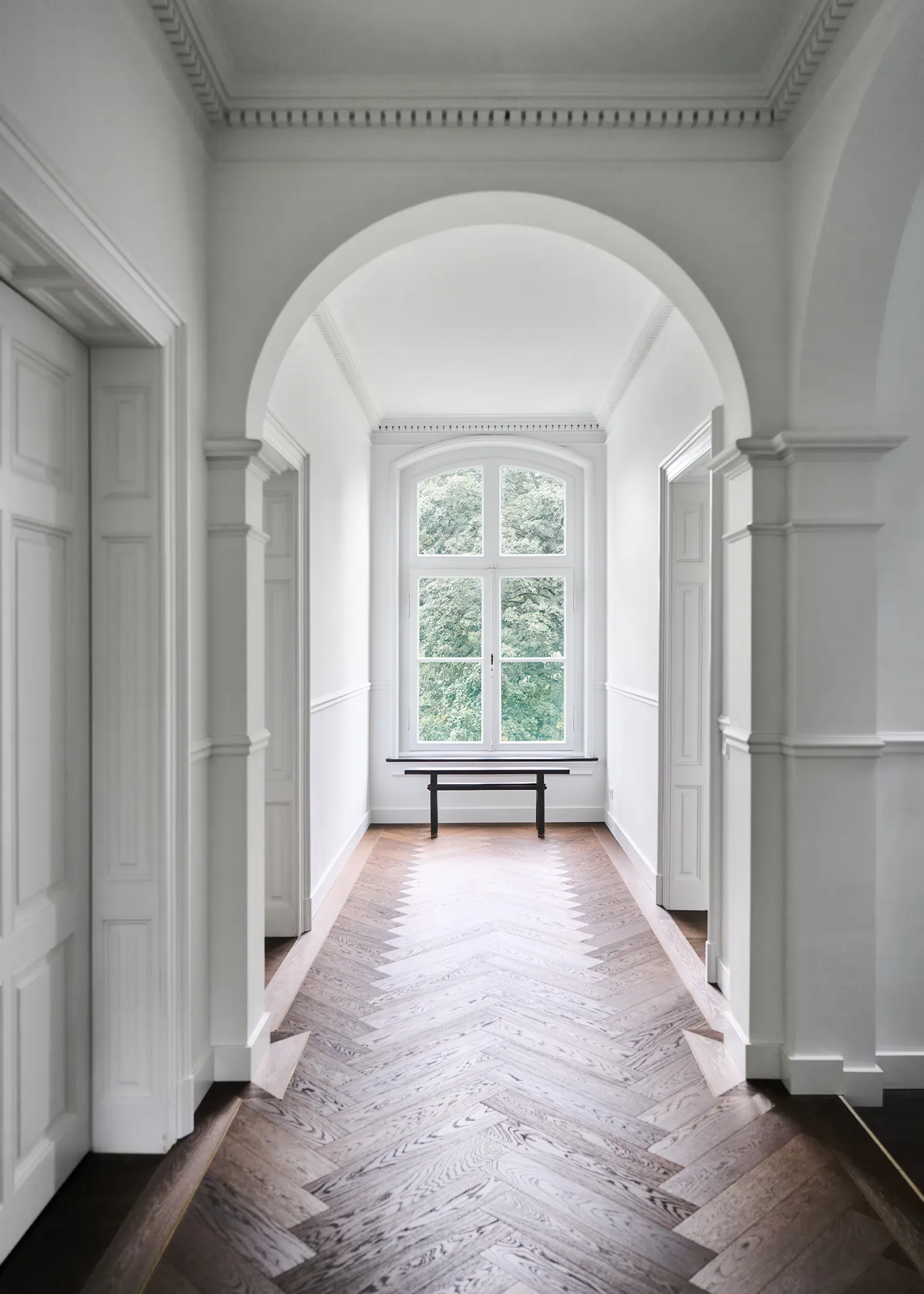 Hal met visgraat houten vloer en klassieke wandlijsten herringbone patroon natuurlijke houtstructuur elegante profilering