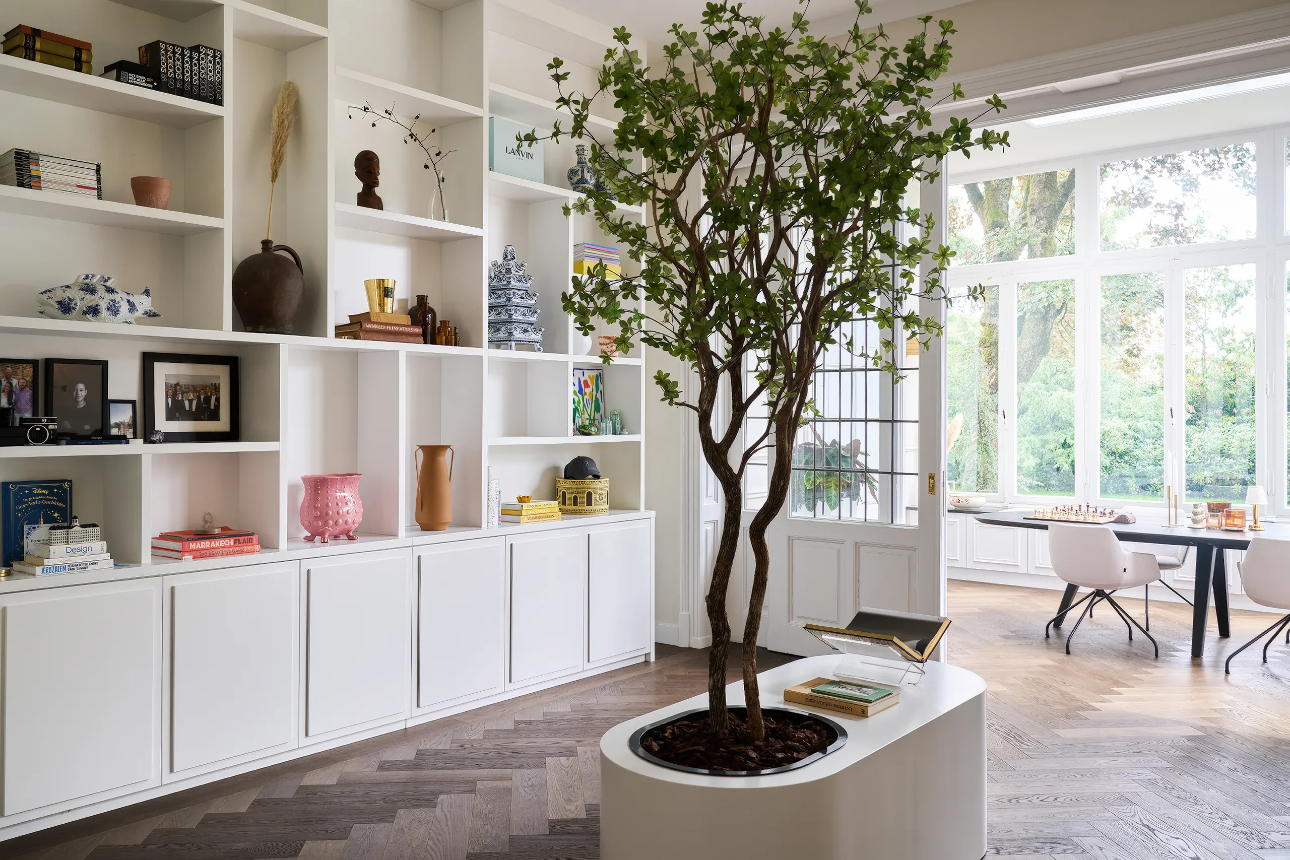 Woonkamer met houten visgraat vloer herringbone patroon vakkenkast en eettafel natuurlijke houtstructuur warm interieur