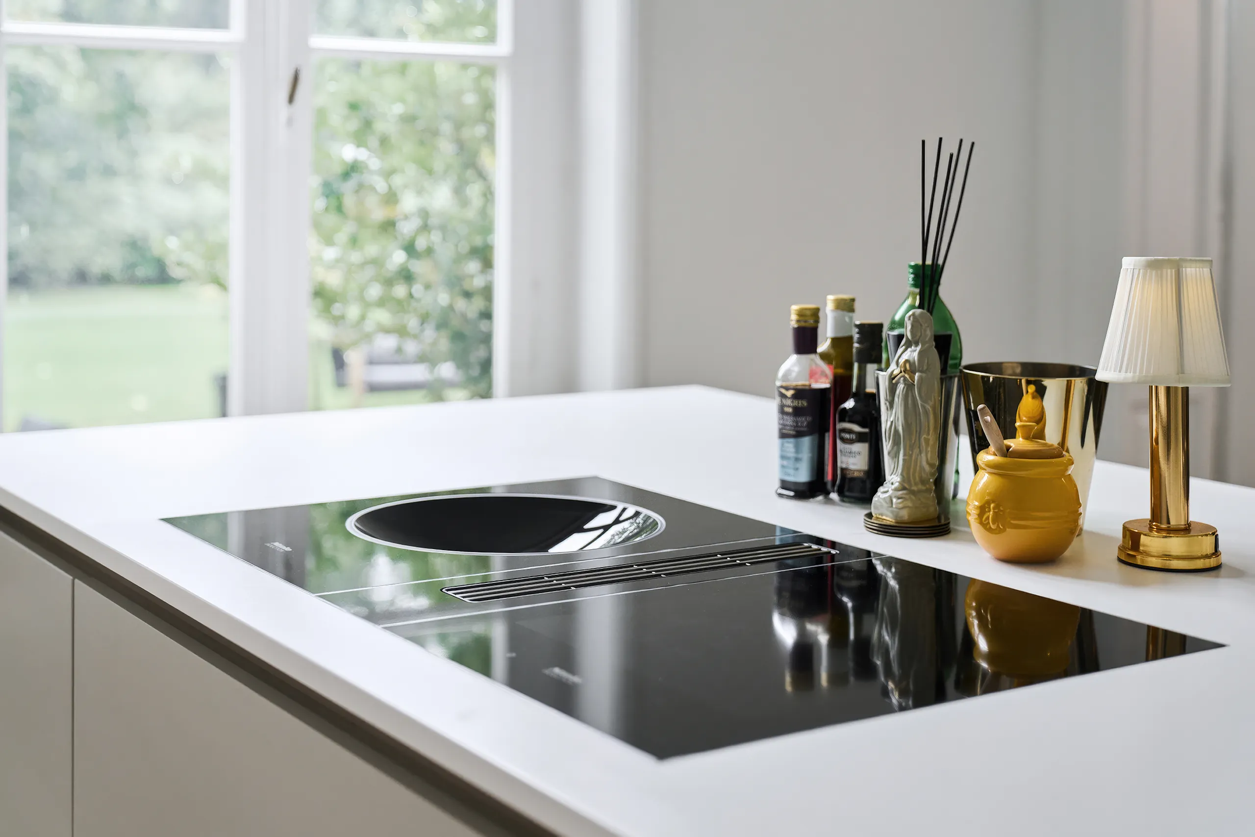 Miele SmartLine inductie-wok met CSDA 7001 FL zwarte werkbladafzuiging en inductiekookplaat op wit Corian solid surface werkblad naadloze afwerking