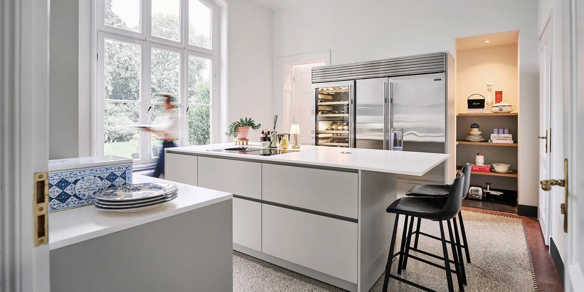 Eggersmann keuken met kookeiland in lichtgrijs greeploos met wit Corian werkblad Sub-Zero en Wolf apparatuur