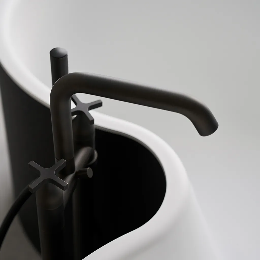 Agape DR vrijstaand bad met ronde organische vormen, zwarte Memory kraan in brushed burnished brass afwerking tegen witte achtergrond