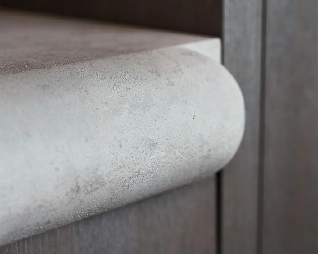 Detailopname luxe Eggersmann keuken met travertin natuursteen werkblad, organisch afgeronde hoeken